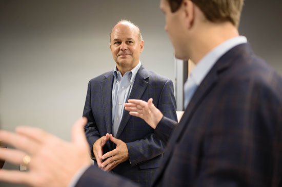 burford caudle provides comprehensive financial services to high-net worth families - photo of conference table meeting with young business man explaining in the forefront